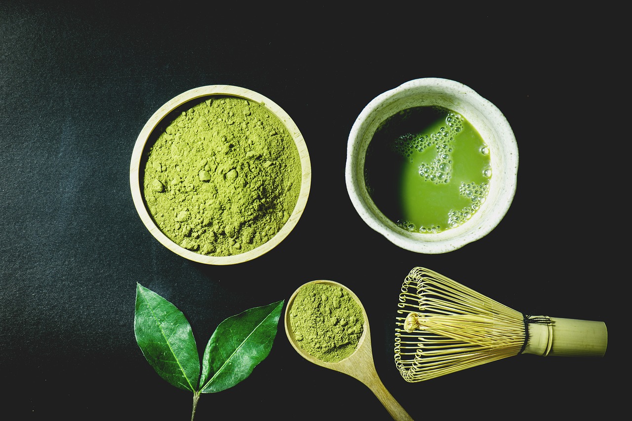 Bol de poudre de matcha vert, thé matcha fouetté, feuille de thé et fouet chasen